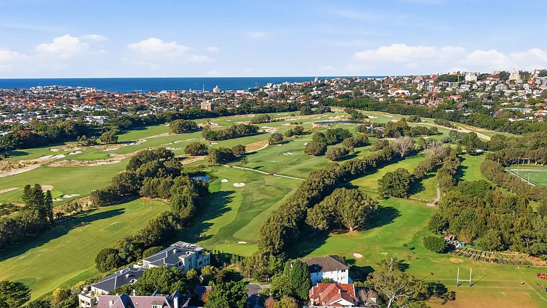an empty golf course fairway near suburban houses