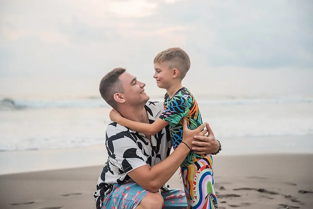 a father and adult son embracing