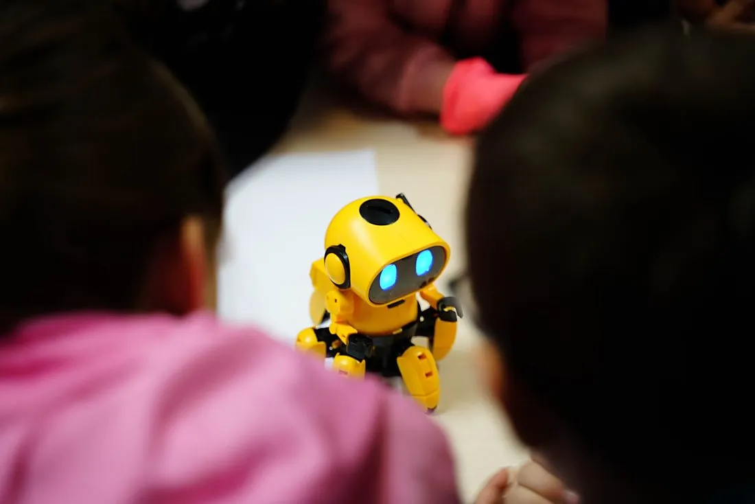 a child holding a small robot shaped like a woodland creature