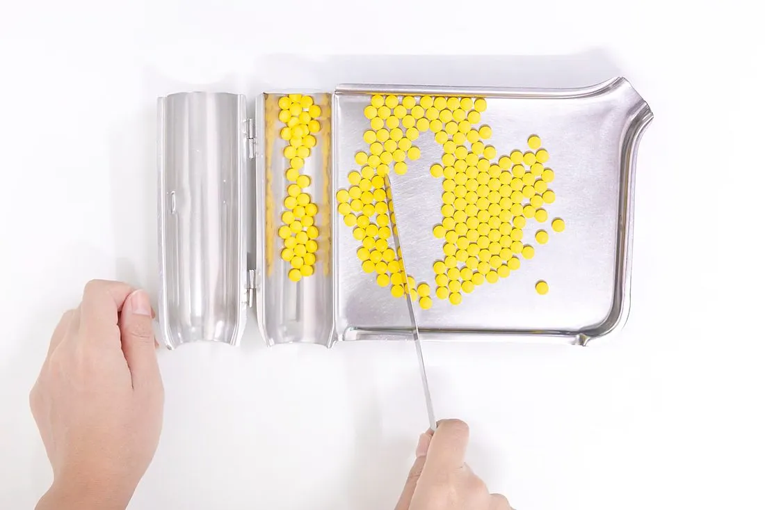 a pharmacist counting pills at a pharmacy counter